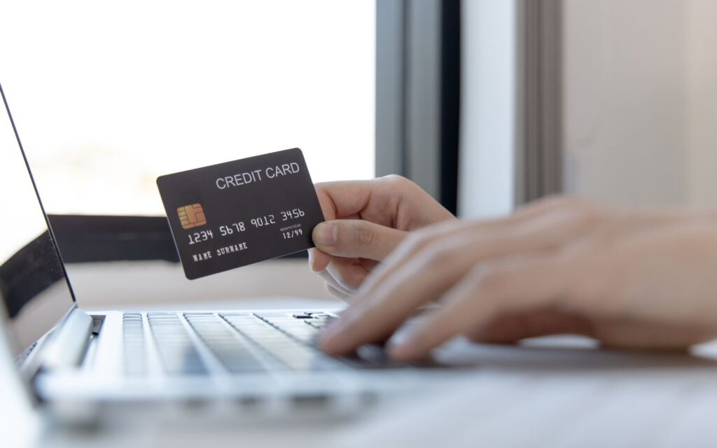 Persona al computer che sa una carta di credito