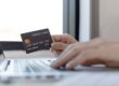 Persona al computer che sa una carta di credito